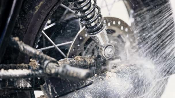 Tvätt med vattenhjul, avgasrör och kedja av klassisk svart motorcykel. Mycket smutsig motorcykel vid tvätt efter off-road körning. Caféer stil, slow motion. Underhåll av motorfordon — Stockvideo