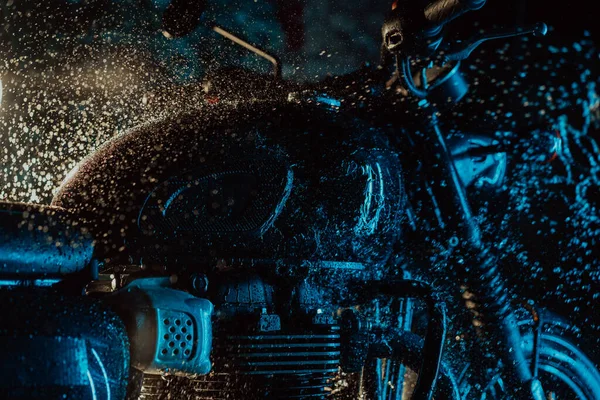 Motorrad im Retro-Stil beim Waschen unter neonblauem Licht. Waschen mit Wasser Details der klassischen schwarzen Motorrad. Caféhausstil. Wartung von Kraftfahrzeugen — Stockfoto