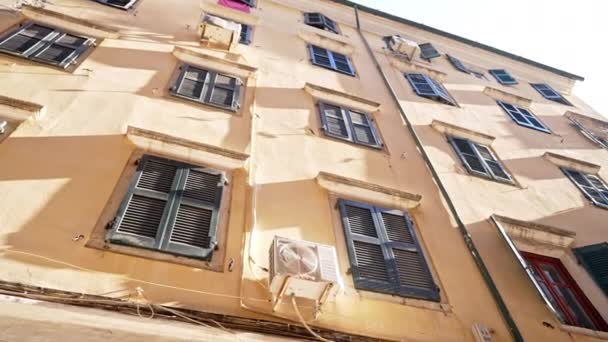 Μεσαιωνικά κτίρια στην Ελλάδα. Steadicam tracking shot της τοπικής πολυκατοικίας στους δρόμους της Κέρκυρας, Κερκίρα. Παράθυρα με παντζούρια. Πρόσωπα παλιών σπιτιών. Έννοια ταξιδιού. — Αρχείο Βίντεο