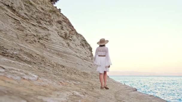 在地中海附近的泥滩上散步的穿着乳白色衣服的时髦女人。享受野外探险的女士，希腊的暑假. — 图库视频影像
