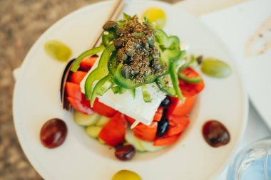 Yunan salatası. Geleneksel sebze yemeği, salatalık, domates, yeşil dolma biber, kırmızı soğan, zeytin ve peynir. Vejetaryen yemeği..