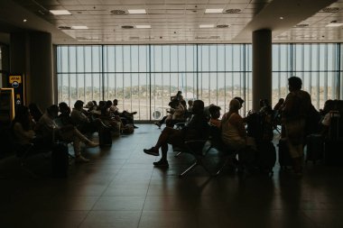 Korfu, Kerkyra, Yunanistan - Eylül 2021. Millet, havaalanındaki koltuklarda oturan yolcular....