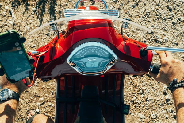 Corfu, Greece - September 2021. Mans hands on steering wheel of red Vespa, guy driving moped or scooter, close-up view. Driver rides motor bike. Handlebars of motorcycle. — Stock Photo, Image