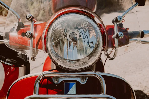 Scheinwerfer eines roten Retro-Rollers. Designdetails des brandneuen Motorrads aus nächster Nähe. — Stockfoto