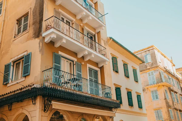 Edifícios medievais na ilha da Grécia. Foto do prédio de apartamentos nas ruas de Corfu, Kerkyra. Janelas com persianas. Fachadas de casas antigas. Conceito de viagem. — Fotografia de Stock