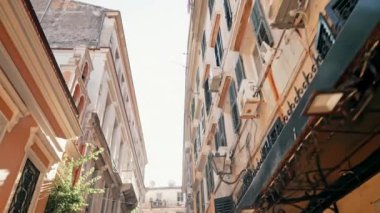 İtalyan şehrindeki güzel apartman binasının buharlı görüntüleri. Panjurlu pencereler. Eski evlerin cepheleri, güney kasabasının dar sokaklarındaki balkonlar. Seyahat konsepti. İnanılmaz güneş parlıyor.