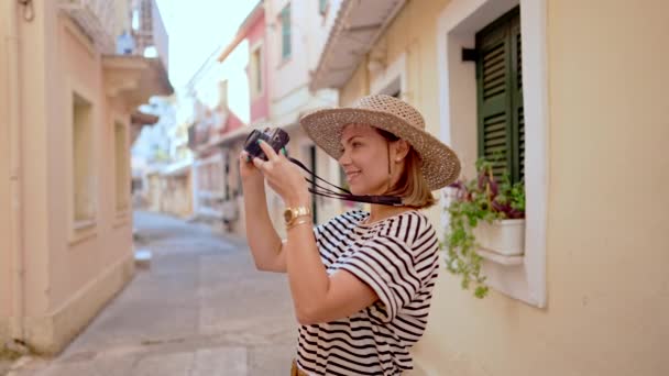 Turystka fotografująca domy, architektura podczas wakacji w starym europejskim mieście. Pani zwiedzająca wąskie uliczki na wyspie Grecja. Fotograf amator robienie zdjęć z małym aparatem cyfrowym. — Wideo stockowe