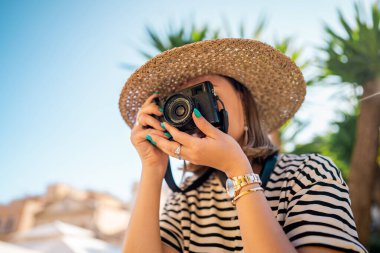 Korfu, Yunanistan - Eylül 2021. Eski Yunan kenti Kerkyra 'da palmiye ağacının altında duran fotoğrafçı. Fujifilm X100 v ile fotoğraf çeken amatör.