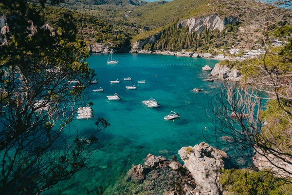Rovinia beach view with clear blue sea water and moored boats. Amazing azure nature background. Private coast on Greece Corfu island, luxury travel sight — Stock Photo, Image