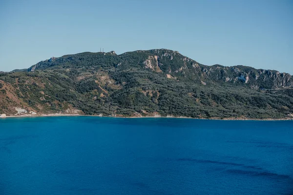 Vista al paisaje marino con agua cristalina azul clara. Increíble fondo azul mediterráneo. destino de viaje, naturaleza universal, complejo, verano Grecia vacaciones en la isla. — Foto de Stock