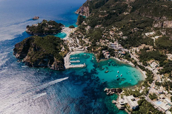 Aerial drone view to Paleokastritsa bay, heart-shaped coast with clear teal sea water. Greece Corfu island. Luxury resort village, boats, yachts. Amazing european seascape. — Stock Photo, Image