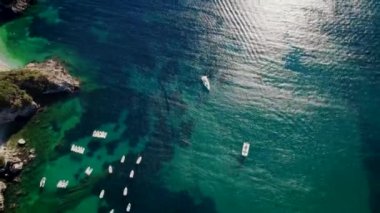 Mavi deniz suyunu, demirli tekne ve yatlarla temizlemek için hava aracı görüntüsü. Mercan resifleri ile muhteşem bir gök mavisi arka plan. Yunanistan 'ın Corfu Adası' ndaki özel plajda demirleme sahaları.