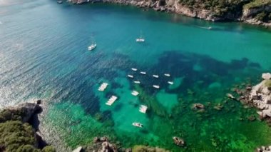 Mavi deniz suyunu, demirli tekne ve yatlarla temizlemek için hava aracı görüntüsü. Mercan resifleri ile muhteşem bir gök mavisi arka plan. Yunanistan 'ın Corfu Adası' ndaki özel plajda demirleme sahaları.