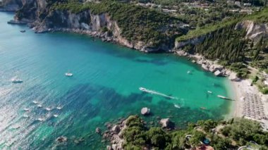 Mavi deniz suyunu, demirli tekne ve yatlarla temizlemek için hava aracı görüntüsü. Mercan resifleri ile muhteşem bir gök mavisi arka plan. Yunanistan 'ın Corfu Adası' ndaki özel plajda demirleme sahaları.