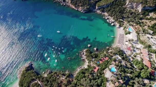 Drohnenblick auf klares blaues Meerwasser mit festgemachten Booten und Yachten. Erstaunlich azurblauer Naturhintergrund mit Korallenriffen. Anker in Bucht in Privatstrand auf der Insel Korfu, Griechenland Reiseziel.