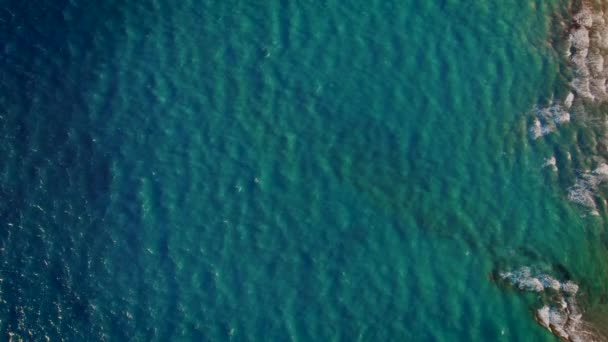 Blick von oben auf klares blaues Meer- oder Meerwasser. Langsame Wellen. Drohnenaufnahmen aus der Luft aus der Höhe. Erstaunlich azurblaue Natur Hintergrund. Kopierraum. — Stockvideo