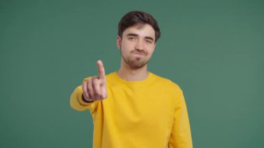 Uninterested Handsome Man Disapproving With Stop Finger Sign. Dont Play with me, enough. Portrait of guy on green background. High quality 4k