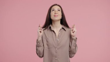 Amerikalı güzel bir kadın dua ediyor, özür diliyor, o suçlu. Pembe arka plan. Umut dolu dua eden bayan birinden arzularını tatmin etmesini ve yardım etmesini istiyor. Yüksek kalite 4k