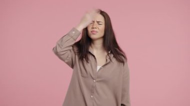 Kafası karışık Amerikalı kadın, hayır, unuttu. Şok olmuş kız üzüntü, pişmanlık, drama, başarısızlık, pembe arka planda sorunlar yaşıyor. Yüz bakımı. Yüksek kalite 4k