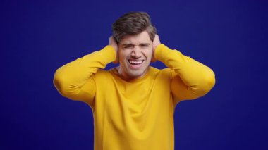 Sarı tişörtlü adam, gürültüyü ya da istenmeyen bilgiyi engelleyerek hayal kırıklığına uğruyor. Stres, aşırı yükleme, çatışma, işyeri anlaşmazlığı, iş bağlamında görüşlerin reddedilmesi.