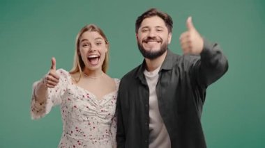 El işaretli güzel bir kadın ve adam, baş parmak hareketi gibi. Mutlu çift, doğru seçim, harika bir anlaşma, yeşil özgeçmiş. Pozitif arkadaşlar kameraya gülümser, onaylar, güven kavramı.