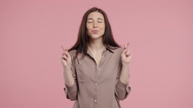 Pembe stüdyo arka planında dua eden hoş bir kadın. Vücut pozitifliği olan kadın, birine arzularını tatmin etmesi için yalvarır, yardım eder, şans için dua eder. Yüksek kalite 4k