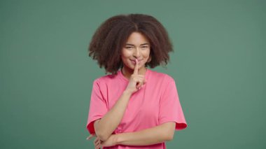 Genç Afrikalı kadın model sakin yüzüyle parmaklarını dudaklarına dayayıp sessizlik istiyor. Gizlilik, dedikodu, söylentiler, odaklanma, mahremiyet, sınırlar, ifade içeriğindeki sessiz iletişim