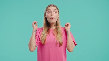 Şaşkın sarışın kadın, vay canına diyor, inanamadım. İlgi çekmeye çalışan etkileyici bir bayan. Satış kavramı, karlı bir teklif. Mavi arka planda heyecanlı öğrenci kız. Yüksek kalite 4k