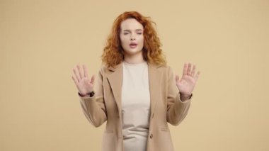 Oldukça sakin bir iş kadını, dinleniyor, bej rengi stüdyoda meditasyon yapıyor. Bayan stresi reddediyor ve durumu kabulleniyor, sakinleşiyor, derin nefes alıyor. Yoga, zen, sağlık yaşam tarzı konsepti. Yüksek kalite 4k görüntü 