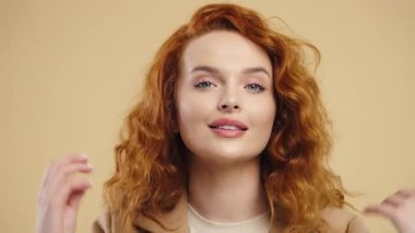 İnanılmaz uzun kıvırcık saçlar. Güzel bir kadın başını sallıyor. Gülümseyen, güzel, sağlıklı, uzun kızıl saçlar, kıvırcık dokular. Yüksek kalite 4k görüntü