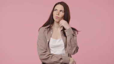 Mutlu kadının fikir üretme anı, pembe arka planı işaret ediyor. Akıllı bir bayan cevap veriyor ya da ne unuttuğunu hatırlıyor, hafıza konsepti. Yüksek kalite 4k