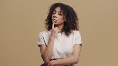 Mutlu kadının aklına bir fikir geldi, bej arka planda parmakla işaret etti. Akıllı bir bayan cevap veriyor ya da ne unuttuğunu hatırlıyor, hafıza konsepti. Yüksek kalite 4k