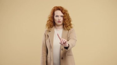 Dur işaretini tasvip etmeyen stil düşkünü genç Amerikalı kadın. Benimle oynama, bu kadar yeter. Bej arka planda bayan portresi. Yüksek kalite 4k