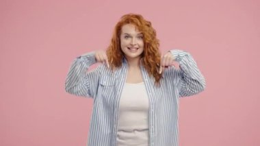 Genç kadın blogcu reklam alanını işaret ediyor. Pembe arka plan. Güzel genç kız aşağıda üye olmak için tıklamak istiyor. Ticari fikir ve tanıtım içeriği için kopyalama alanı. Yüksek kalite 4k 