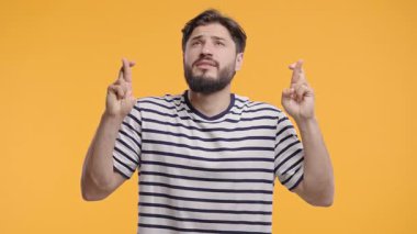 Olgun sakallı adam parmaklarını çapraz yapar ve sessizce dua eder, beklenti ya da umut ifade eder. Şans, önemli sonuçlar, iş riskleri, profesyonel hayattaki yüksek bahisli anlar.