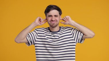 Tişörtlü adam, gürültüyü ya da istenmeyen bilgiyi engelleyerek hayal kırıklığıyla tepki veriyor. Stres, aşırı yükleme, çatışma, işyeri anlaşmazlığı, iş bağlamında görüşlerin reddedilmesi.