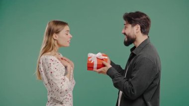 Yeşil stüdyo geçmişi olan genç bir Amerikalı çift. Beyaz sakallı adam, karısı ya da kız arkadaşına selam verir. Doğum günü, kutlama, sürpriz, yıldönümü konsepti. Yüksek kalite 4k görüntü