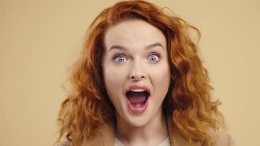 Şaşırtıcı derecede şoke edici kızıl kadın, vay canına diyor, inanamıyorum. İlgi çekmeye çalışan etkileyici bir bayan. Satış kavramı, karlı bir teklif. Bej arka planda heyecanlı bir öğrenci kız. Yüksek kalite 4k