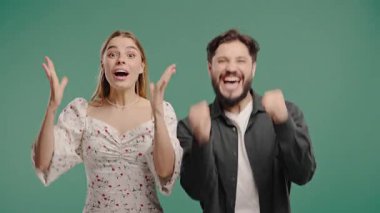 Kadın ve erkek kameraya gülümserken zaferle yumruklarını kaldırır. Başarı, çift kutlaması, motivasyon, başarı veya duygusal tepki içeriği. Yüksek kalite 4k görüntü