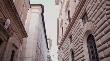 Kamera Roma caddelerinde süzülüyor, pencereli apartman cephelerini yakalıyor. Seyahat, şehir keşfi, kültürel konsept.