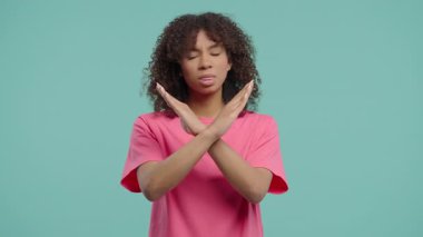 Hayır, asla, güzel bir Afrikalı Amerikalı kadın el işaretini keserek jestten hoşlanmaz ve reddeder. Onaylamayan hoş bir kadın, mavi stüdyo arka planında 