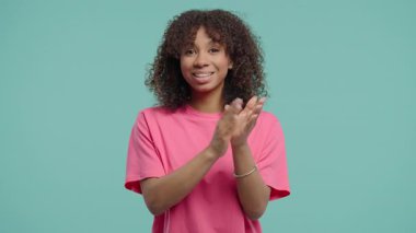 Kendine güvenen çekici bir kadın açık bir gülümseme ve aktif bir vücut diliyle alkışlıyor. Kutlama, olumlu ifade, tebrik, tezahürat, minnettarlık, bravo konsepti..