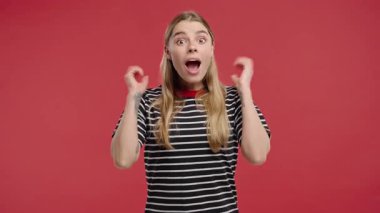 Şok olmuş çekici sarışın kadın, vay canına diyor, inanamıyorum. İlgi çekmeye çalışan etkileyici bir bayan. Satış kavramı, karlı bir teklif. Kırmızı arka planda heyecanlı öğrenci kız. Yüksek kalite 4k