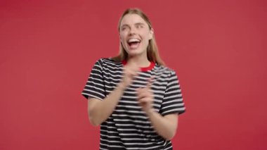 Şanslı güzel kadın eğleniyor, favori müzik, gülümsüyor, kırmızı stüdyo arka planında dans ediyor. Müzik, dans konsepti, 4k