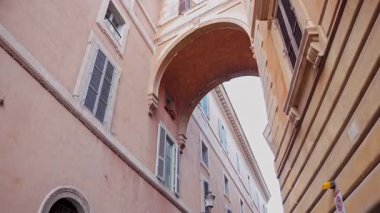 Popüler seyahat yeri. Yürüyen kişinin öznel sabit görüntüsü. Pastel duvarları olan klasik Roma yerleşim cephesi. Günlük Roma yaşamının eski duvar ustalığı ve cazibesi.