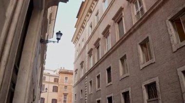 Popüler seyahat yeri. Yürüyen kişinin öznel sabit görüntüsü. Pastel duvarları olan klasik Roma yerleşim cephesi. Günlük Roma yaşamının eski duvar ustalığı ve cazibesi.