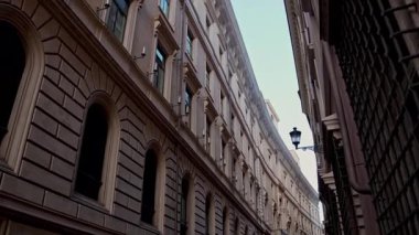 Popüler seyahat yeri. Yürüyen kişinin öznel sabit görüntüsü. Pastel duvarları olan klasik Roma yerleşim cephesi. Günlük Roma yaşamının eski duvar ustalığı ve cazibesi.