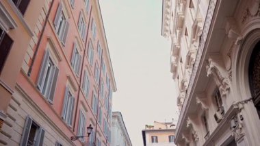 Popüler seyahat yeri. Yürüyen kişinin öznel sabit görüntüsü. Pastel duvarları olan klasik Roma yerleşim cephesi. Günlük Roma yaşamının eski duvar ustalığı ve cazibesi.