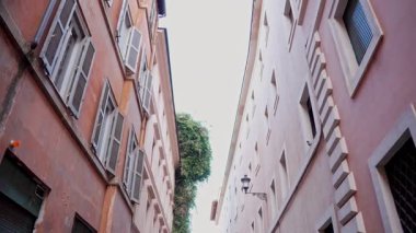 Popüler seyahat yeri. Yürüyen kişinin öznel sabit görüntüsü. Pastel duvarları olan klasik Roma yerleşim cephesi. Günlük Roma yaşamının eski duvar ustalığı ve cazibesi.