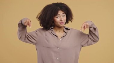 Genç kadın blogcu reklam alanını işaret ediyor. Bej arka plan. Güzel genç kız aşağıda üye olmak için tıklamak istiyor. Ticari fikir ve tanıtım içeriği için kopyalama alanı. Yüksek kalite 4k